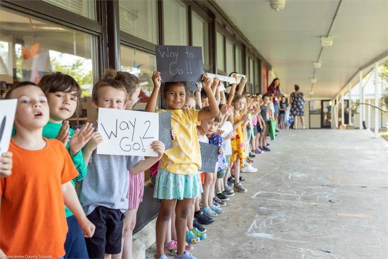 Students holding handmade signs in the in the breezeway Students holding handmade signs in the in the breezeway