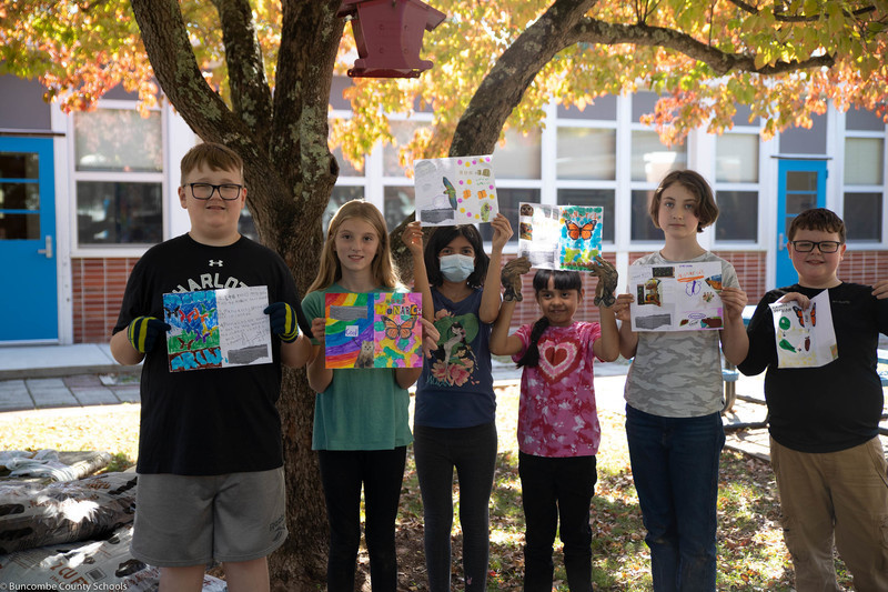 Students showing off their butterfly work they've created. 