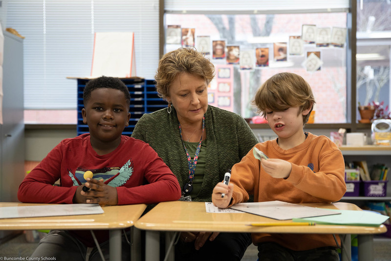 Ms. Kertesz assisting students in the classroom. 