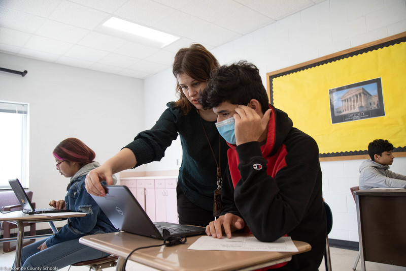 Teacher helping student with a project.