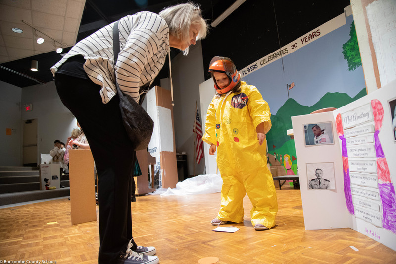 Parent listening and observing a student presentation.