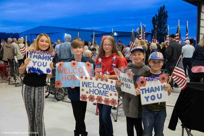Students holding up their welcome home signs.