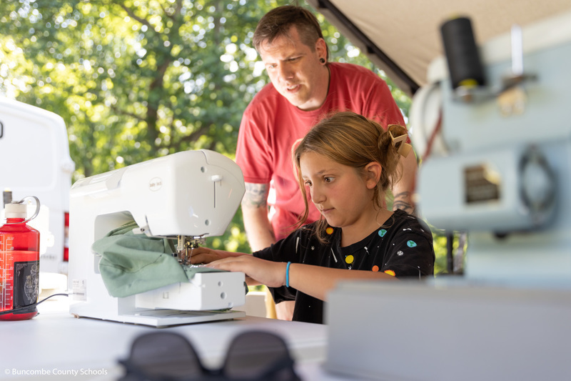 Student sewing a drawstring backpack.