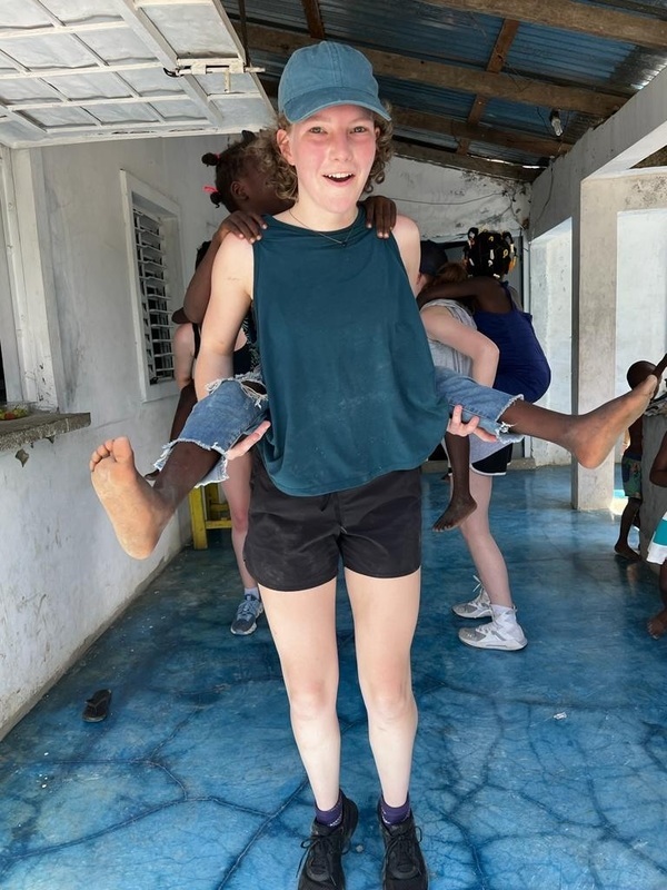 Owen High student giving a piggyback ride to a younger child. 