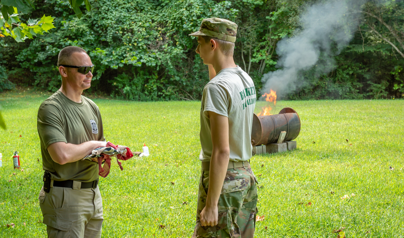 A JROTC student saluting the American flag. 