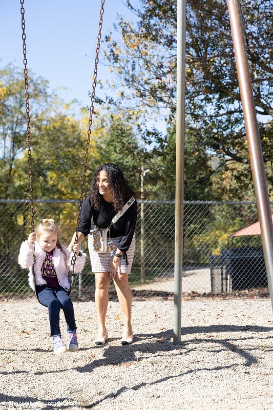 Mrs. Trantham pushing a student on a swing.