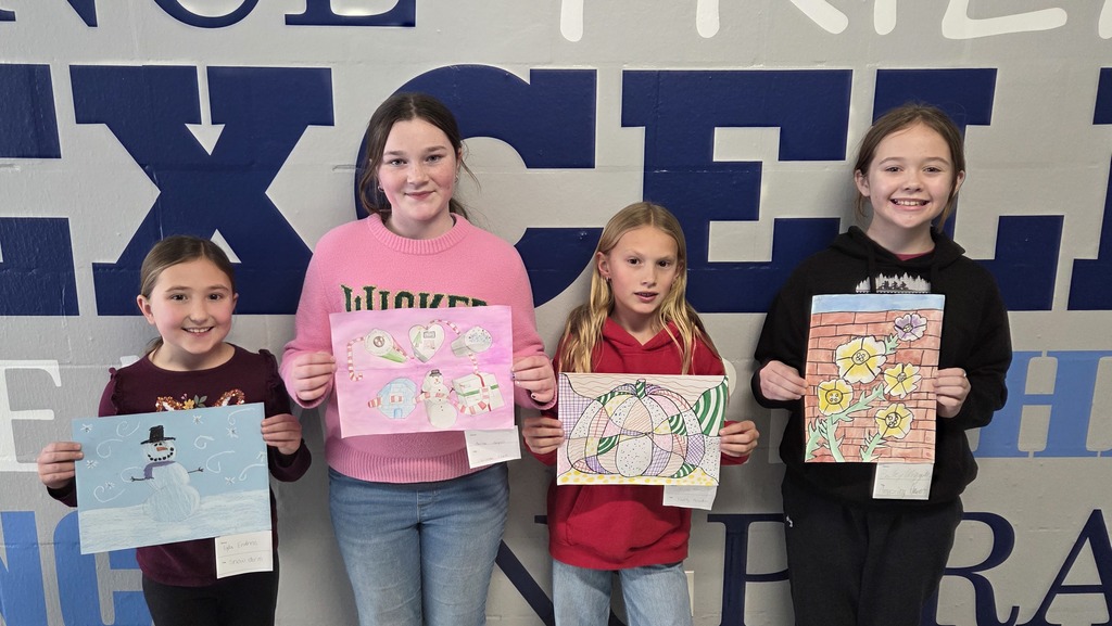Four students holding their artworks that were selected for the Art Exhibit.