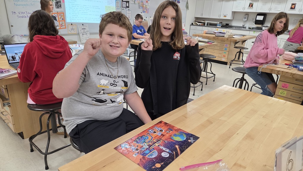 Students showing their finished puzzle.