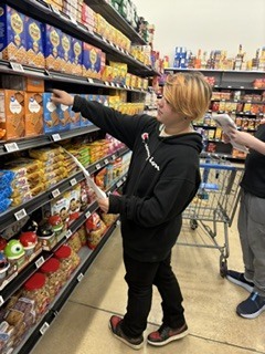 Student is taking an item off a shelf.