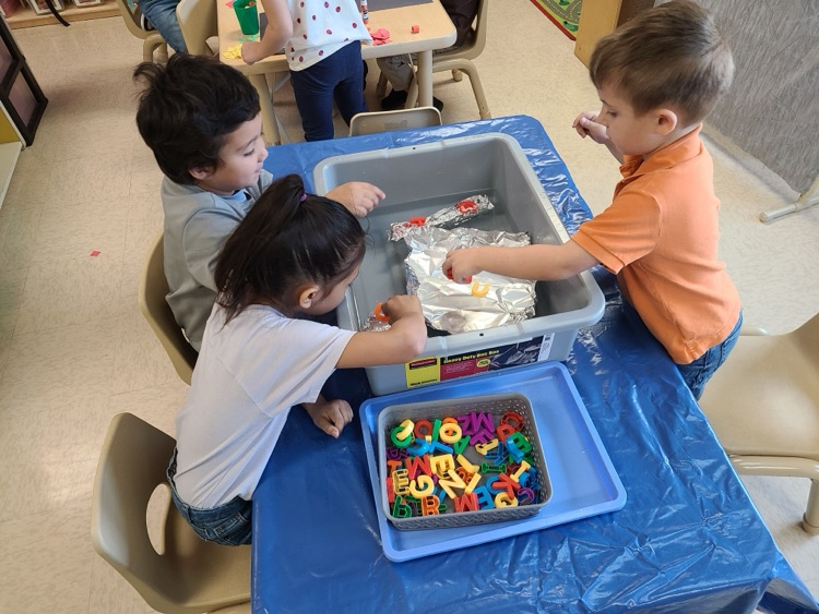 PreK students work on a science project