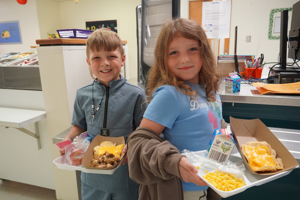 students holding trays of nachos