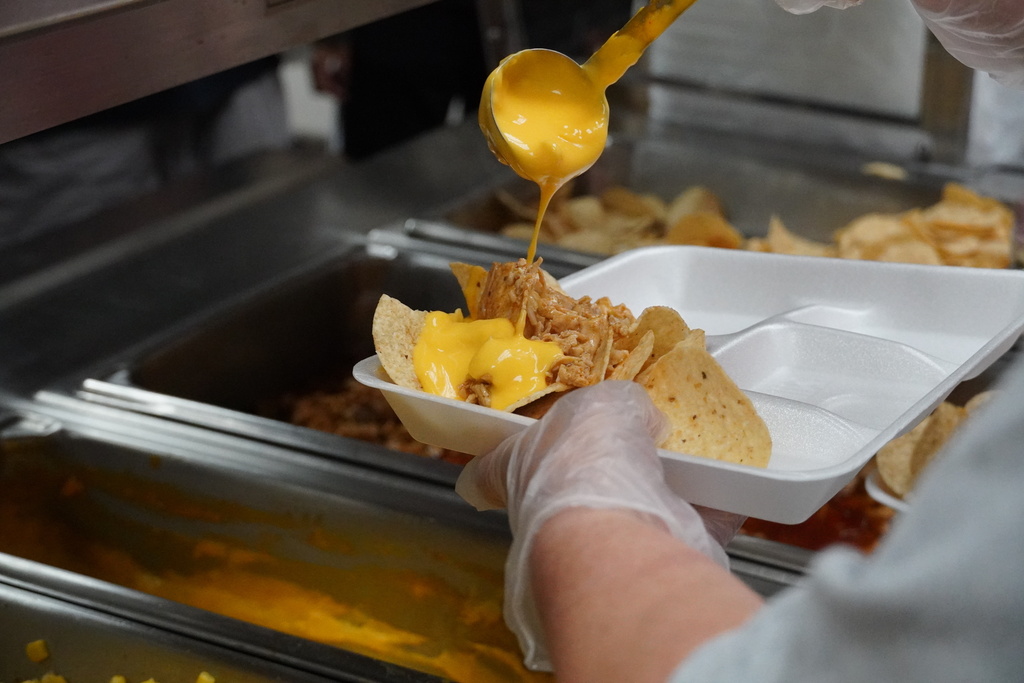 close up of cheese drizzled on nachos