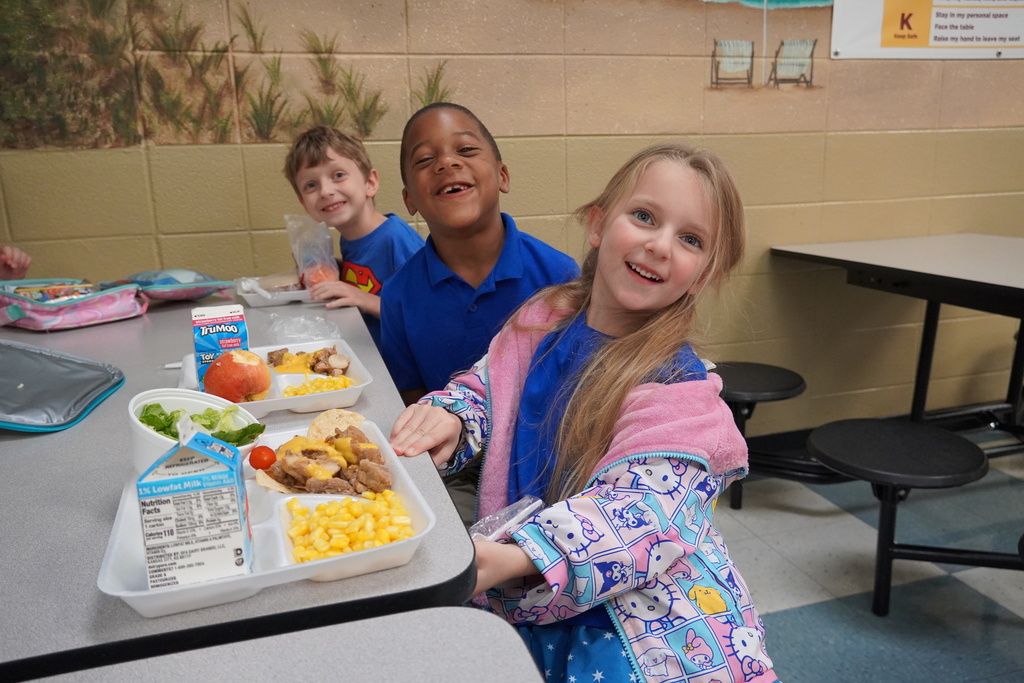 students smiling at lunch table with nachos