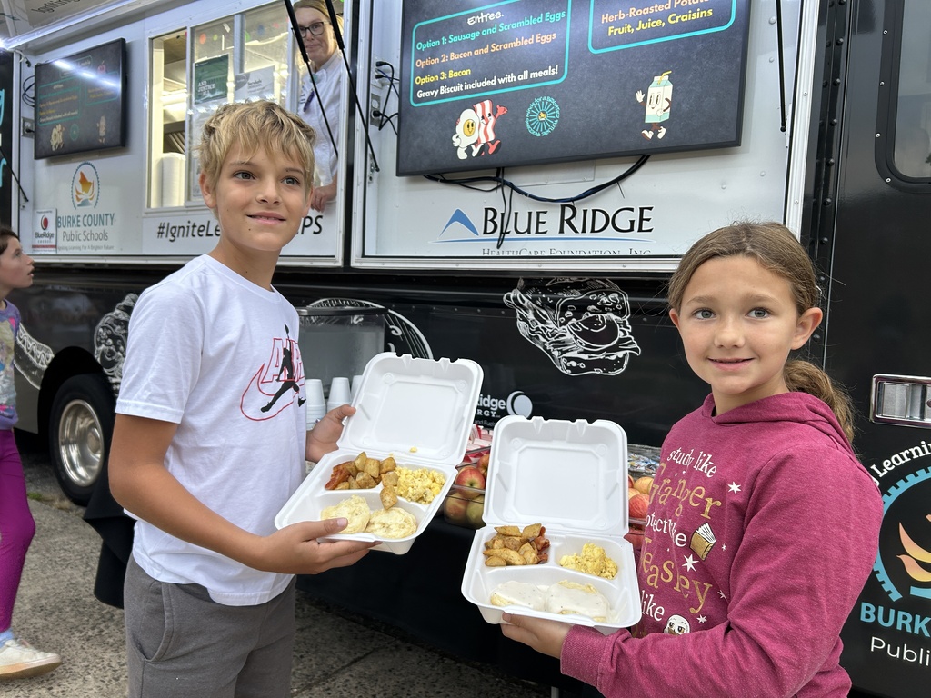 students hold trays open showing food