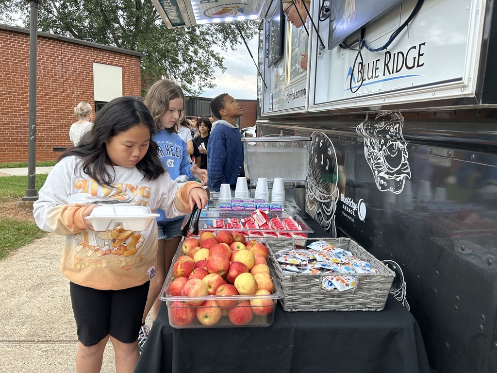 student takes an apple from the side table