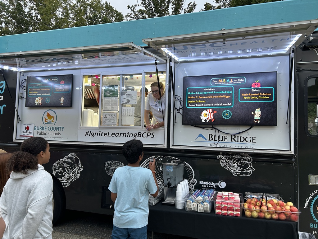 students tell their order to the food truck employee from the food truck window