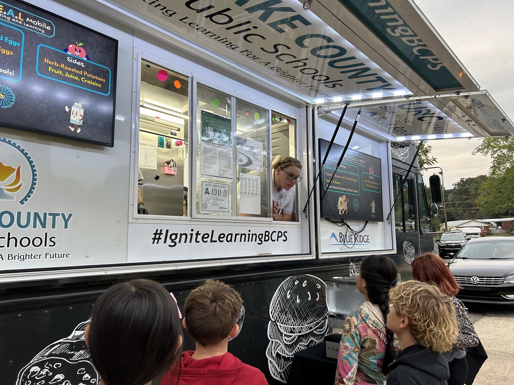 staff takes the order of a student from the food truck window