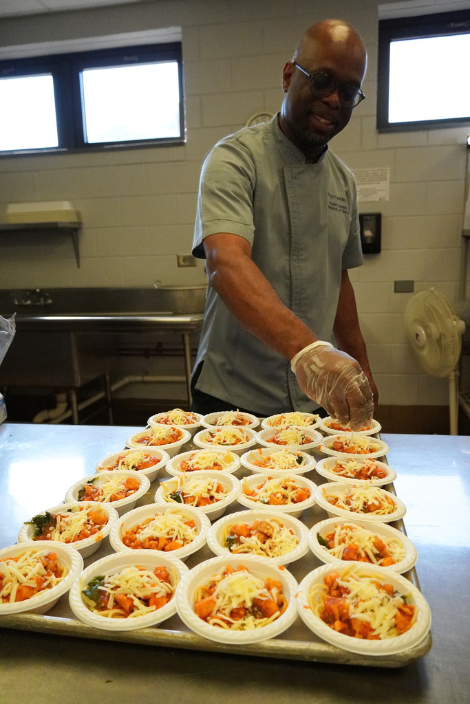 chef adding cheese to a tray full of samples