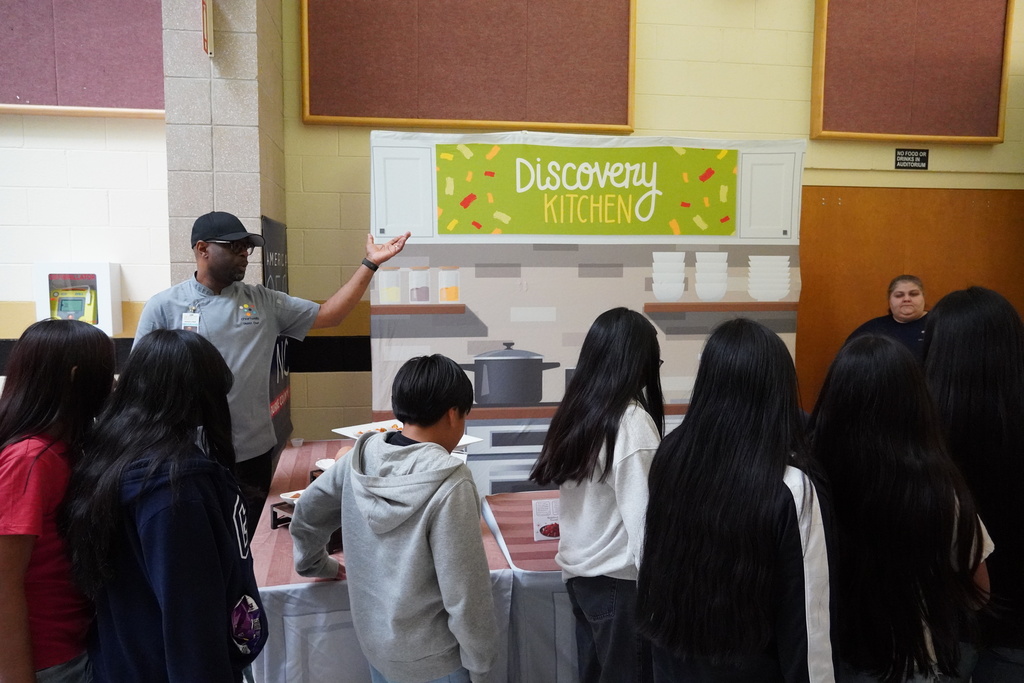 chef speaking to students while they grab samples
