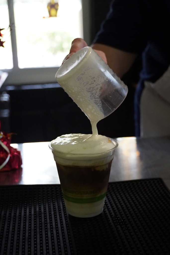 adding cold foam to the top of a coffee