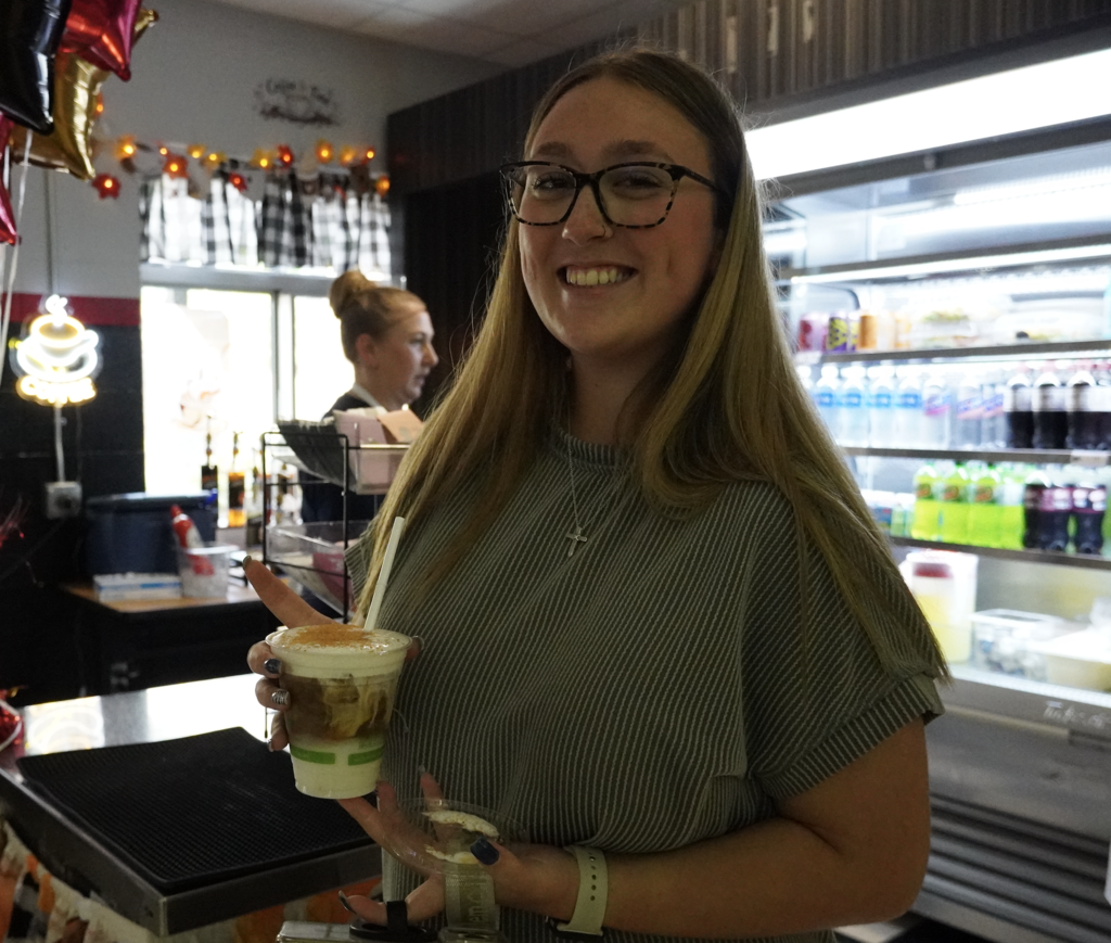 student holds an iced coffee