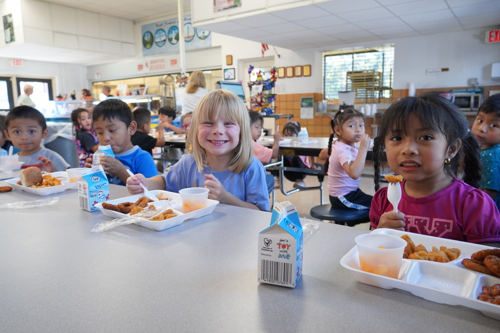 students smiling with lunch tray