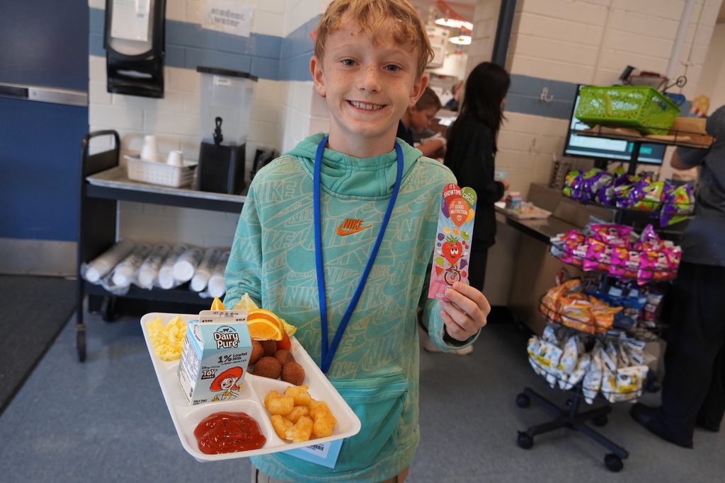 student holds a bookmarker with tray
