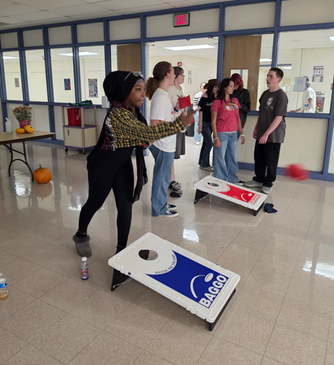 Students playing games at the fall festival event at medford. Playing corn hole.