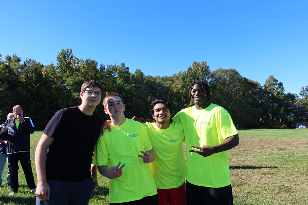 Four male students posing for the camera on the filed. 