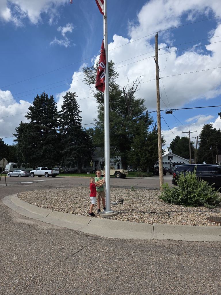 Two students at the flag pole.