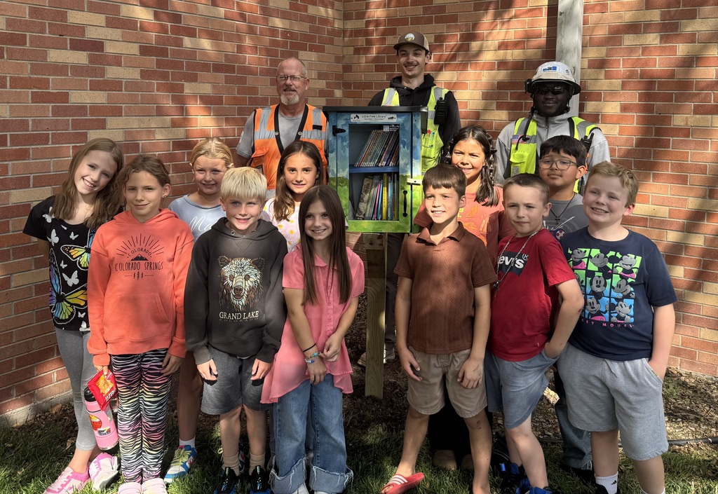Students taking a picture with the new free library.
