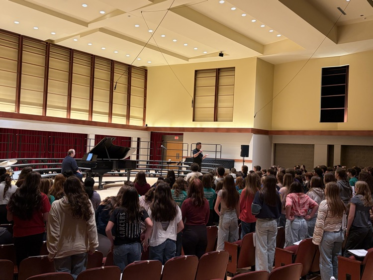 choir students in auditorium warming up to sing