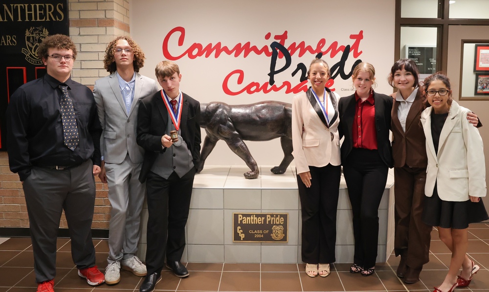 Group of 3 boys and 4 girls standing front of panther statue.