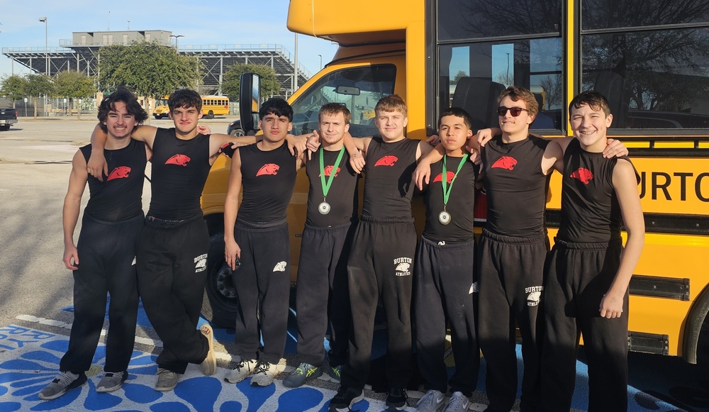 Group of boys in front of school bus.