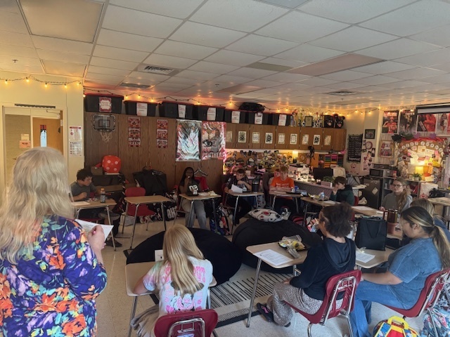 Group of students sitting in desks arranged in a u shape