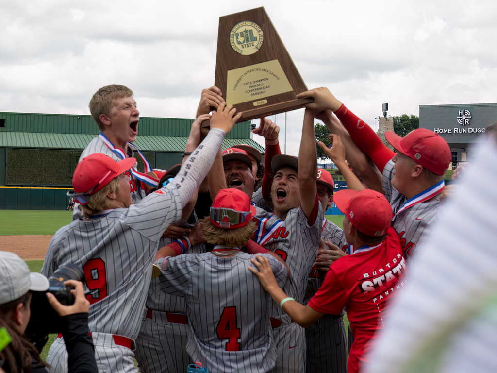 group of high school boys cheering and lifting the UIL baseball trophy over their heads