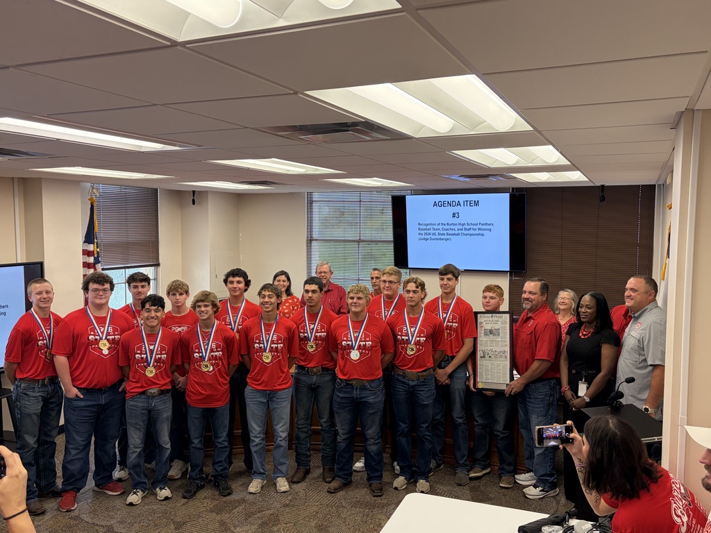 Group of high school boys in matching shirts being presented with the Banner Press while coaches look on
