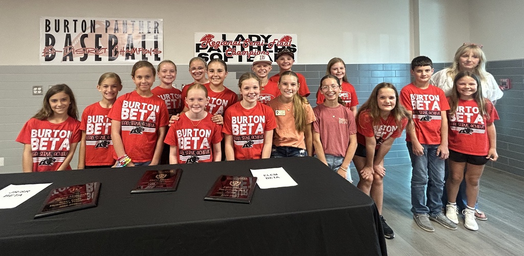 Group of elementary students smile with an adult woman 