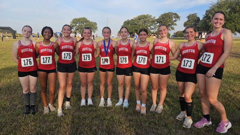 Group of girls in XC uniforms smiling at the camera
