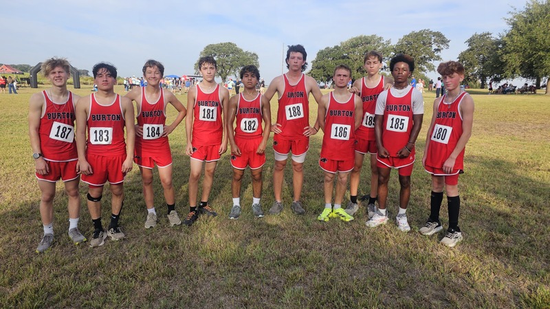 Group of boys in red XC uniforms smiling at the camera