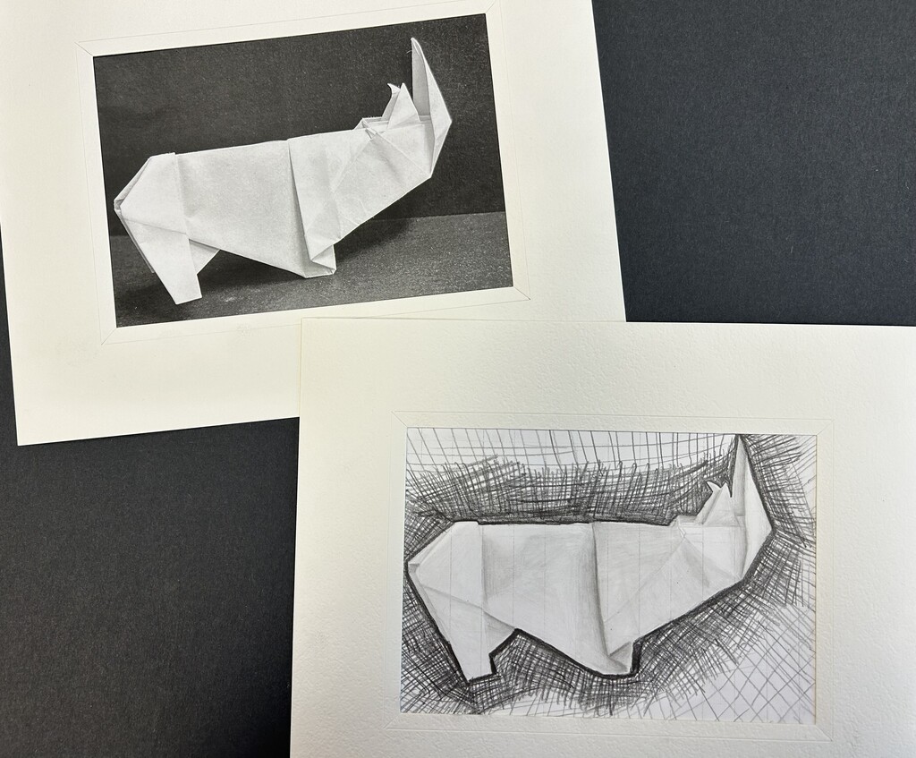 Two framed artworks displayed side by side, each depicting a white origami figure resembling a standing bird or abstract animal. The left artwork is a pencil drawing of the folded-paper figure against a textured, grassy background; the right is a photograph of the three-dimensional origami figure against a dark background.