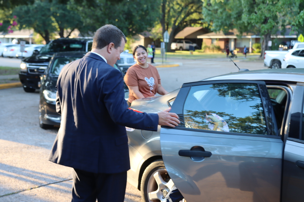 Mr. Burton helps students out of the car at Shreve Islane Elementary