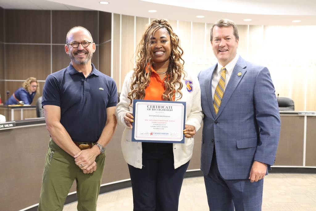Principal LaToria Grant of Southwood High School celebrates with Superintendent Burton and President Little regarding Southwood's Purple Star School Designation