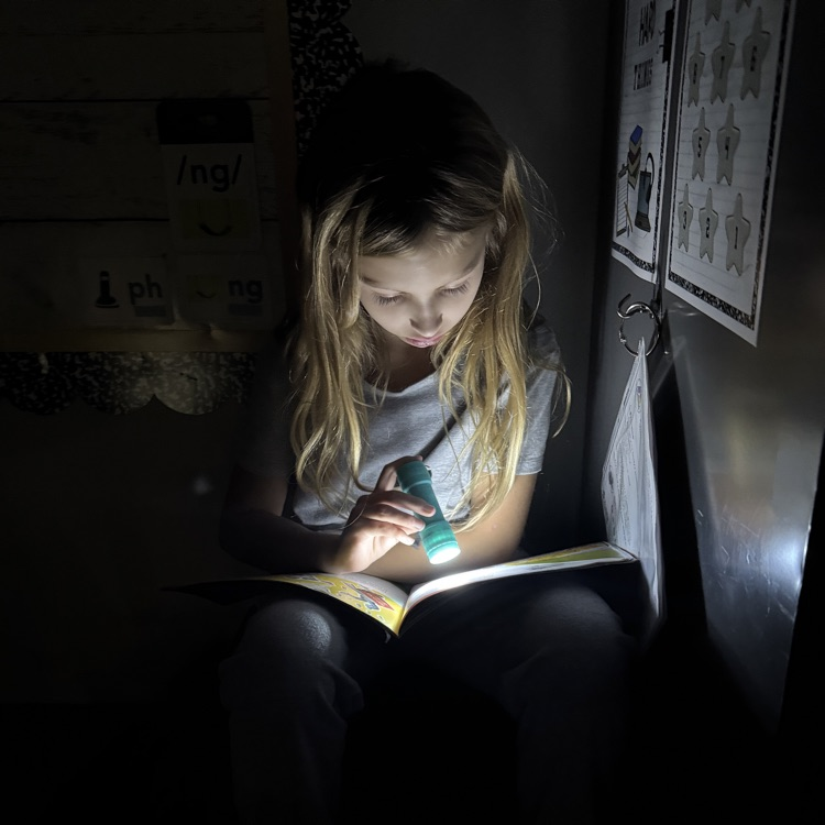 students reading by flashlight