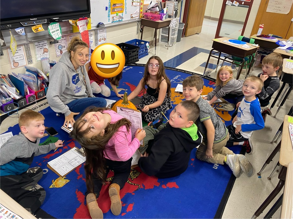 Students sitting in a circle with a pumpkin