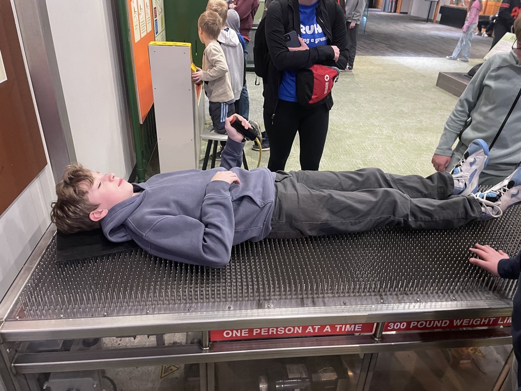 student laying on a bed of nails 