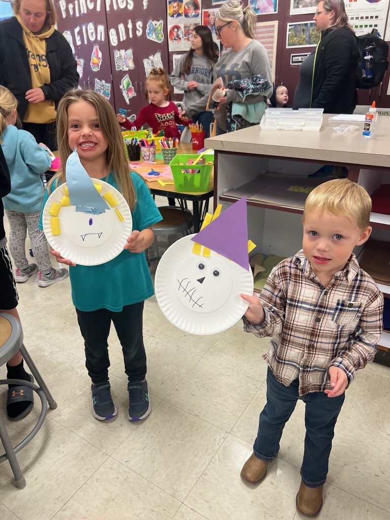 Two students showing off their scarecrows they made.  