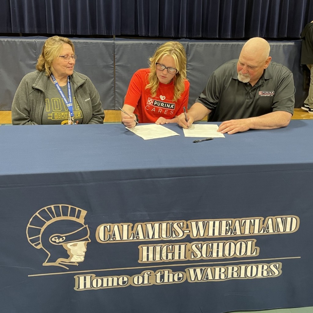 JoEllen signing with Purina along side Mrs. Petersen