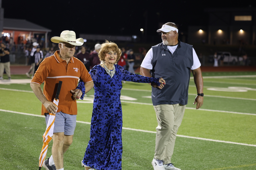 🧡 𝗢𝗡𝗖𝗘 𝗔 𝗛𝗢𝗥𝗡𝗘𝗧, 𝗔𝗟𝗪𝗔𝗬𝗦 𝗔 𝗛𝗢𝗥𝗡𝗘𝗧. 🧡  Friday night’s Homecoming was made extra special by a very special guest — 𝗦𝘁𝗲𝗽𝗵𝗶𝗻𝗮 (𝗡𝗮𝘃𝗿𝗮𝘁𝗶𝗹) 𝗗𝗶𝗗𝗼𝗻𝗮𝘁𝗼, Caldwell High School Class of 1951.  At 94 years young, Stephina traveled all the way from Delaware to come home to Caldwell. She spent the day touring CHS and visiting band rehearsal before making the most of Friday night under the lights.  Under the Friday night lights, she 𝗰𝗼𝗻𝗱𝘂𝗰𝘁𝗲𝗱 𝘁𝗵𝗲 𝗛𝗼𝗿𝗻𝗲𝘁 𝗕𝗮𝗻𝗱 𝗶𝗻 𝘁𝗵𝗲 𝘀𝗰𝗵𝗼𝗼𝗹 𝗮𝗹𝗺𝗮 𝗺𝗮𝘁𝗲𝗿, 𝗽𝗿𝗼𝘂𝗱𝗹𝘆 𝗙𝗟𝗜𝗣𝗣𝗘𝗗 𝘁𝗵𝗲 𝗰𝗼𝗶𝗻 𝗳𝗼𝗿 𝘁𝗵𝗲 𝗼𝗽𝗲𝗻𝗶𝗻𝗴 𝘁𝗼𝘀𝘀, 𝗮𝗻𝗱 𝗵𝗲𝗹𝗽𝗲𝗱 𝗰𝗿𝗼𝘄𝗻 𝗼𝘂𝗿 𝟮𝟬𝟮𝟲 𝗛𝗼𝗺𝗲𝗰𝗼𝗺𝗶𝗻𝗴 𝗤𝘂𝗲𝗲𝗻.   Seventy-five years after graduating from CHS, Stephina reminded us that the years may pass and generations may change, but 𝒚𝙤𝒖 𝒏𝙚𝒗𝙚𝒓 𝒓𝙚𝒂𝙡𝒍𝙮 𝙨𝒕𝙤𝒑 𝒃𝙚𝒊𝙣𝒈 𝒂 𝑯𝙤𝒓𝙣𝒆𝙩.  Thank you for coming home, Stephina. 𝗧𝗵𝗶𝘀 𝗶𝘀 𝗼𝗻𝗲 𝗛𝗼𝗺𝗲𝗰𝗼𝗺𝗶𝗻𝗴 𝘄𝗲 𝘄𝗼𝗻’𝘁 𝘀𝗼𝗼𝗻 𝗳𝗼𝗿𝗴𝗲𝘁. #CaldwellProud #CaldwellISD