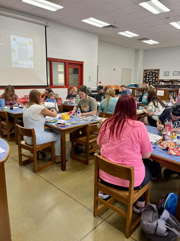 Group of people sitting at tables watching a video